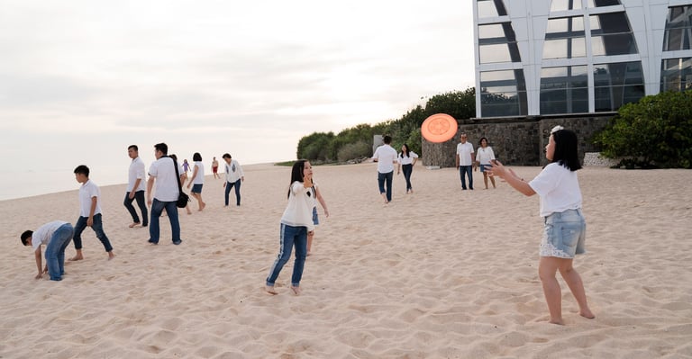 Family playing together on the sandy beach during a relaxed family photography session at The Ritz-Carlton Bali Nusa Dua