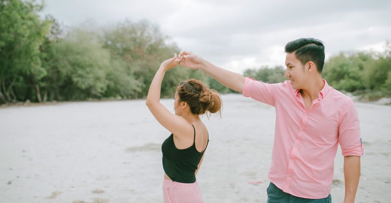 Playful couple twirling on the beach during an intimate session in Serangan Benoa Bali.