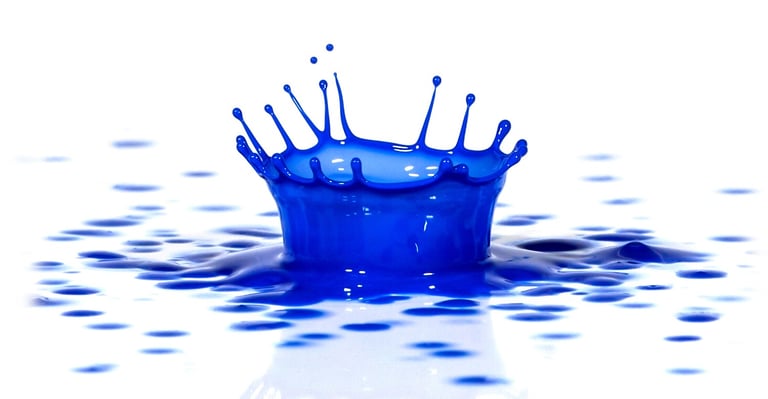 Blue paint splash macro image on a white surface