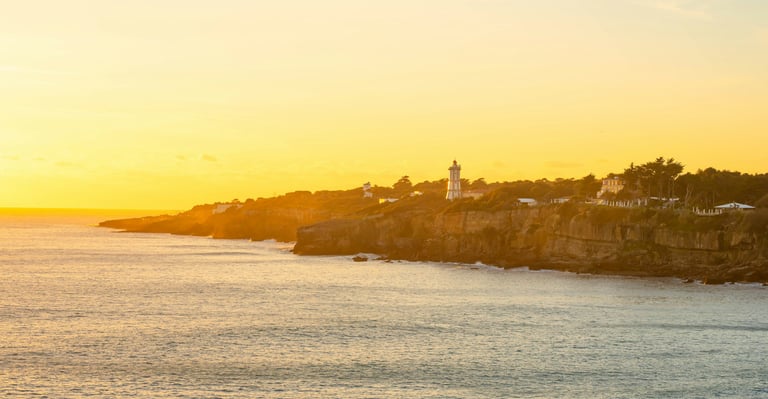 Falaises de Cascais vues de la mer au coucher du soleil, Portugal.