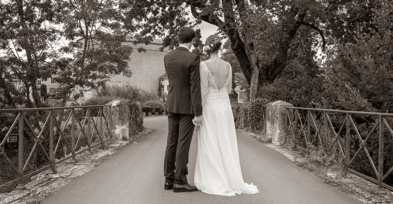 Deux jeunes mariés de dos sur un pont