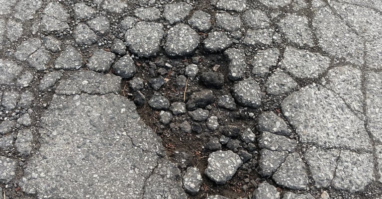 Allegator crack turning into a pothole with major asphalt chipout