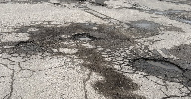 Multiple potholes in London Ontario plaza parking lot
