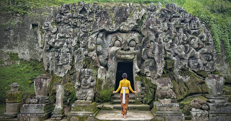 Entrance of Goa Gajah Temple in Ubud, Bali, featuring an ancient stone face carved into the rock