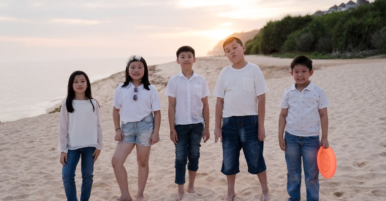 Extended family standing together along the beach at The Ritz-Carlton Bali in Nusa Dua