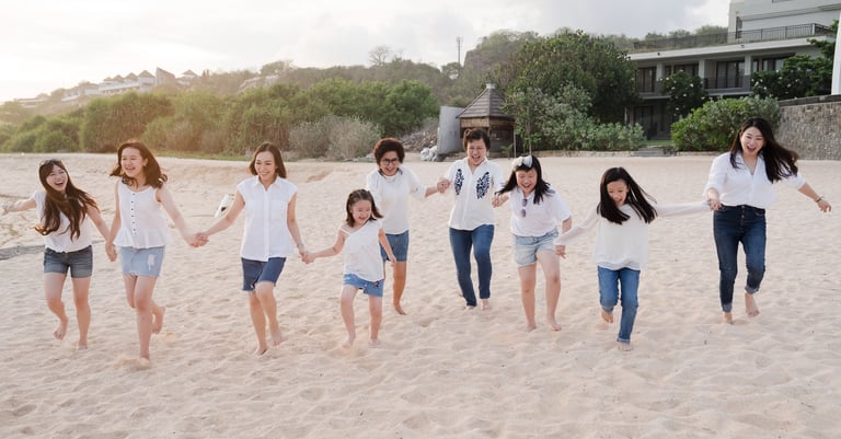 Extended family portrait standing together on the beach at The Ritz-Carlton Bali Nusa Dua