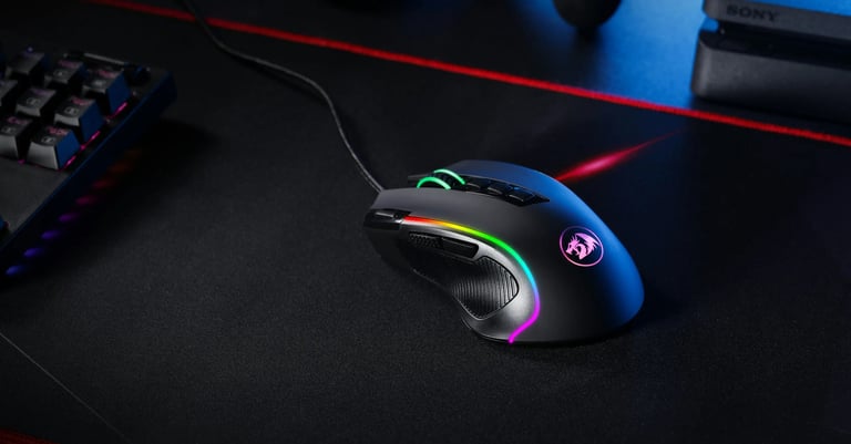 ratón gaming negro con RGB sobre una mesa negra y un teclado