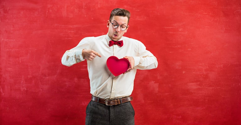 Hombre sosteniendo regalo de San Valentín corazón con un fondo rojo