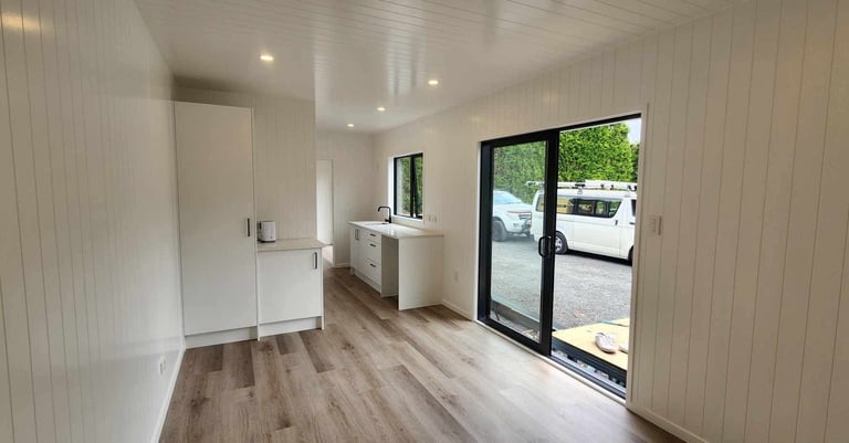 View of kitchen cupboard and sliding door of tiny home