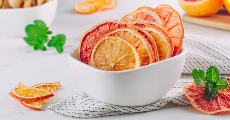 Bowl de cerámica con rodajas deshidratadas de pomelo, naranja y limón.