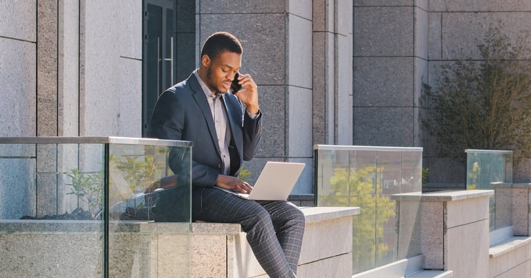 a man in a suit and tie is sitting on a ledge