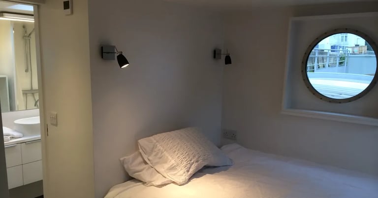 Een kamer op een woonboot met een patrijspoort