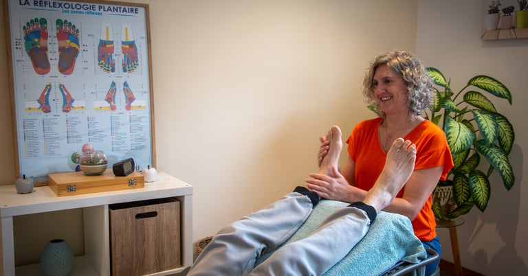 femme assise dans un cabinet pose les mains sur les pieds d'une personne allongée