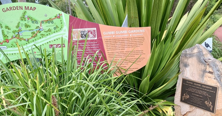 Informational signage and garden map at Gumbi Gumbi Gardens featuring indigenous plant education and history.