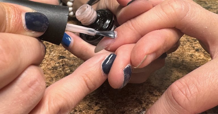 Alex applying polish to acrylic nails in downtown Missoula