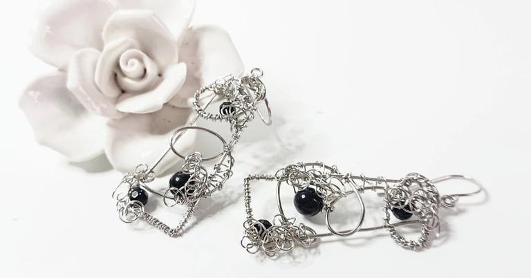 Earrings of steel wire handshaped in oblong with blue goldstone nestled with curls