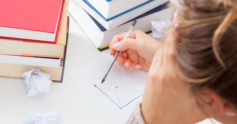 a woman is sitting at a desk with a pencil and pencil