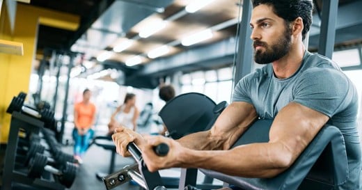 a man in a gym room with a barbell