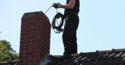 A Chimney being inspected from the roof