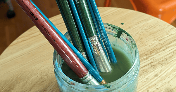 Artist's brushes in an artist's brush water jar.