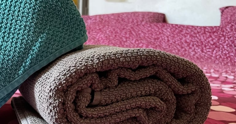 Serviettes de bains pliées sur un lit