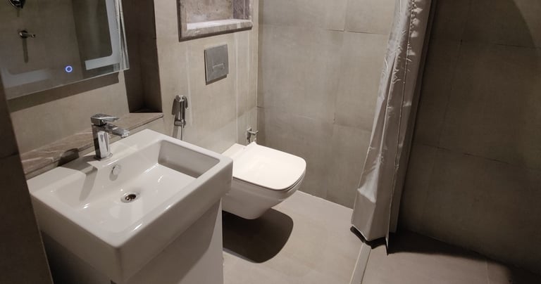 a bathroom with a shower and a toilet at Zenith Suites - Noida, Supernova, Supertech