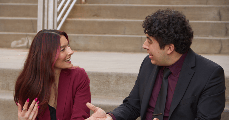 Quesada-Stoner and Gregg sitting to next to each other on stairs chatting excitedly