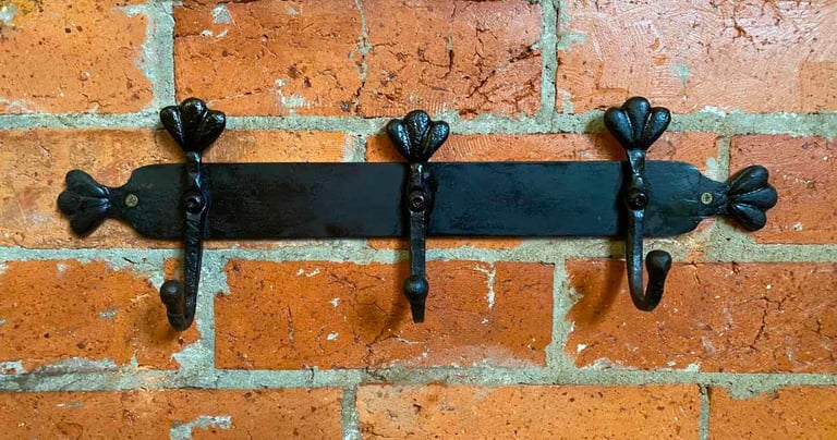 Metal Coat rack attached to brick wall