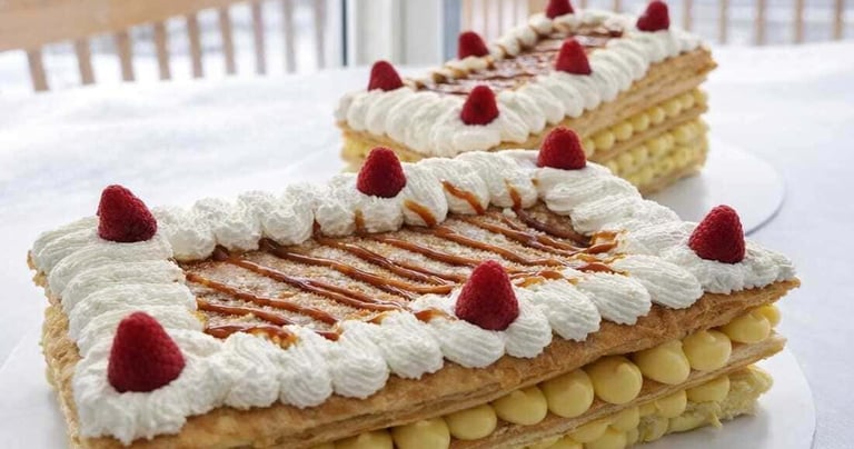 Pasteles de hojaldre con crema pastelera de vainilla, crema batida y frambuesas 