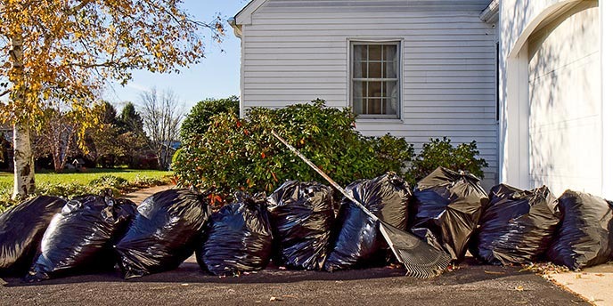 Image of a stack of garbage bags outside a house from cleanup