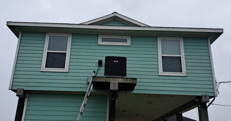 a man standing on a ladder ladder to repair an AC Unit
