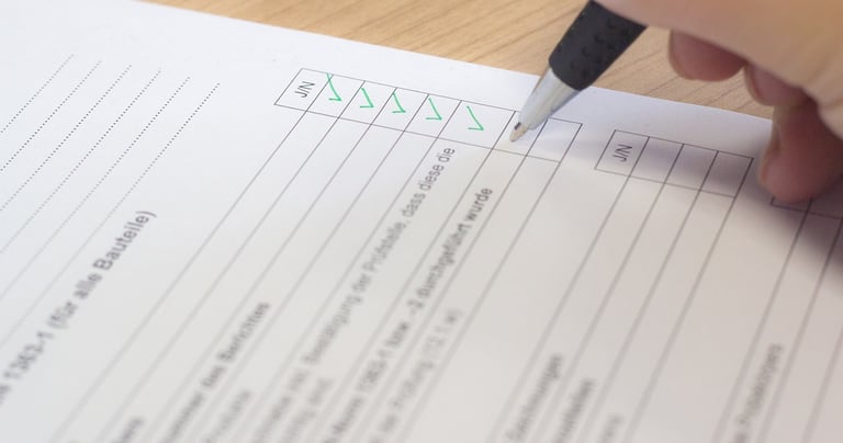 a person holding a pen and writing on a paper