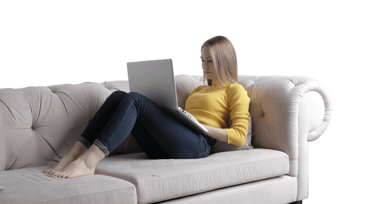 a woman sitting on a couch with her legs crossed receiving online grief therapy