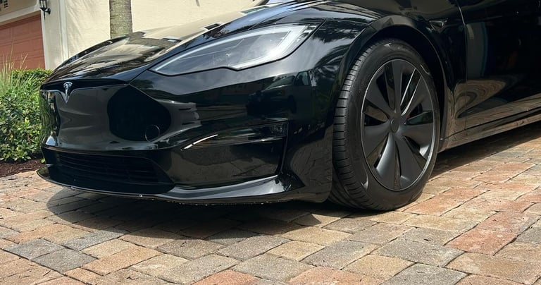 a black tesla tesla parked in front of a house