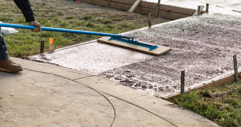 a man is using a blue broom to clean the concrete
