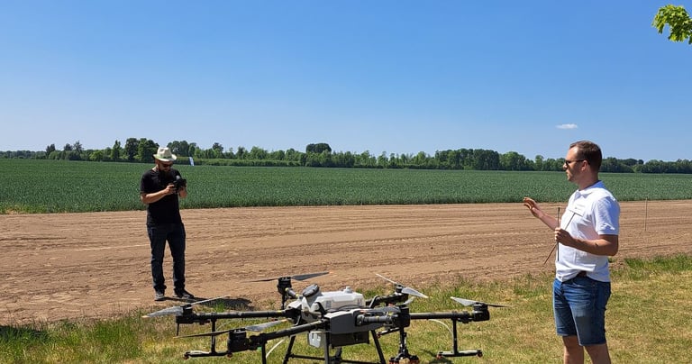 standing in a field with a remote and a drone