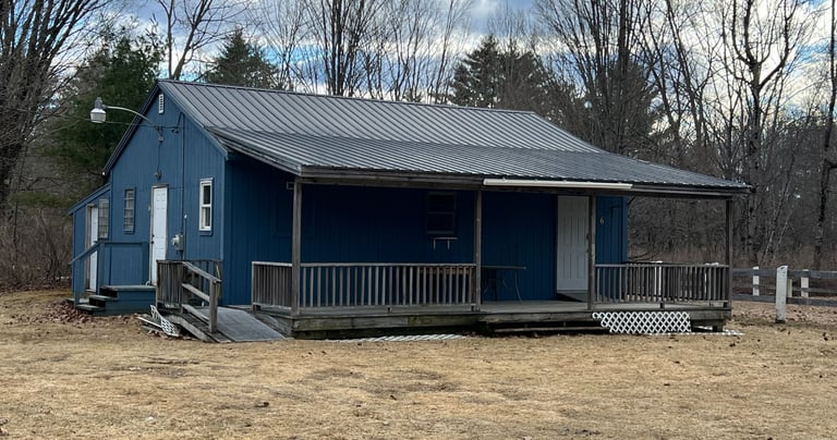 a small blue clubhouse with a metal roof