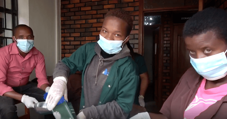 a group of people wearing masks and gloves preparing coffee