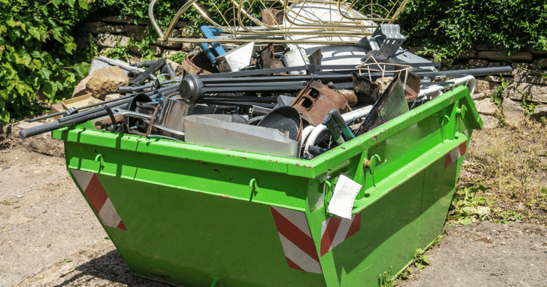 a green dumpster full of scrap metals