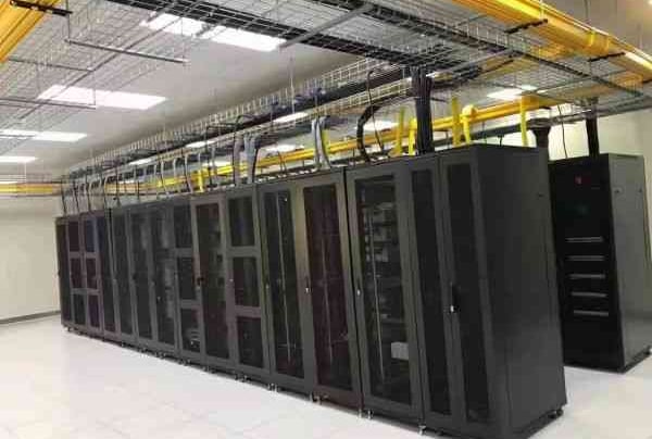 a large machien room with yellow fiber cable trays and wire mesh cable trays