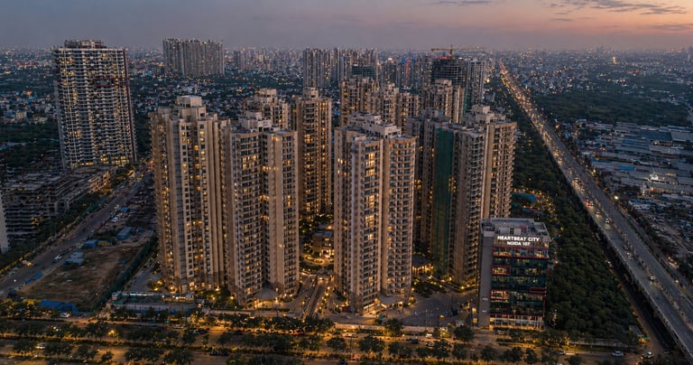Aerial sunset view of Heartbeat City Noida Sector 107 luxury residential high-rise apartments and city skyline.