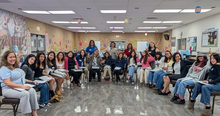 A group of mostly women sits in a cheerful, pastel-decorated room, suggesting a friendly meeting or workshop.
