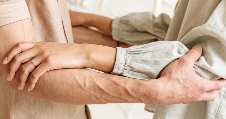 a man and woman holding hands and looking at each other
