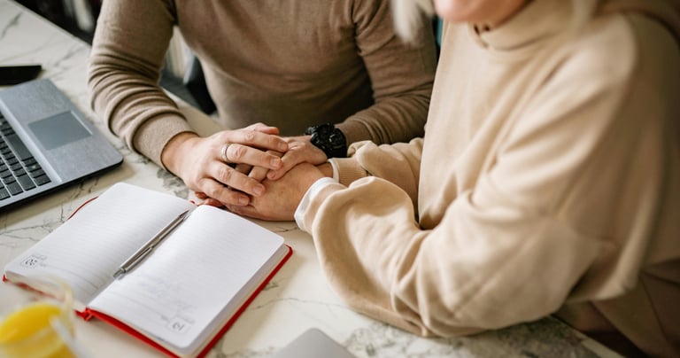 a man and woman holding hands over a notebook