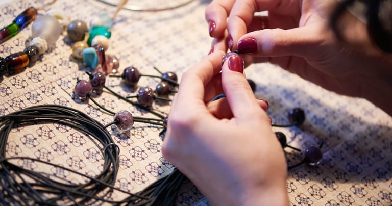 Artesano de joyería hecha a mano, cuentas de vidrio moradas en un cordón negro