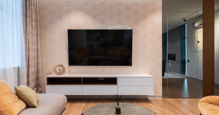 Modern living room featuring a wall-mounted TV over a white floating console with geometric wallpaper.