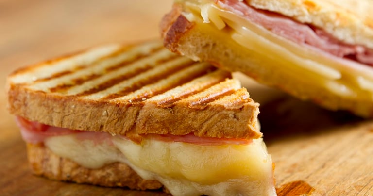 a sandwich sandwich with cheese and ham on a wooden board