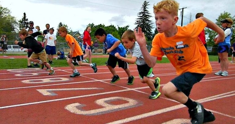 A photo of kids racing a track workout at a Race Ready Events Youth Coaching Clinic