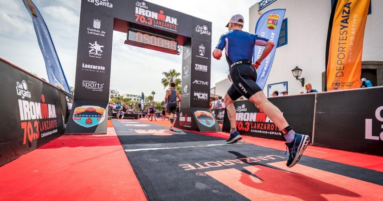 A photo of an Ironman 70.3 athlete crossing the finish line of the running event
