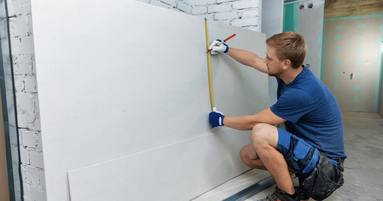 a man is measuring a wall with a tape measure tape
